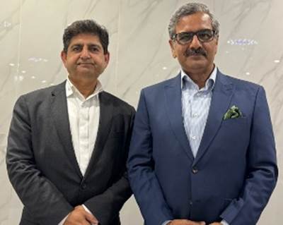 Two men in suits posing for a picture
Description automatically generated