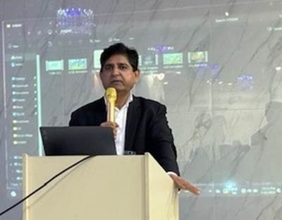 A person standing at a podium holding a microphone
Description automatically generated