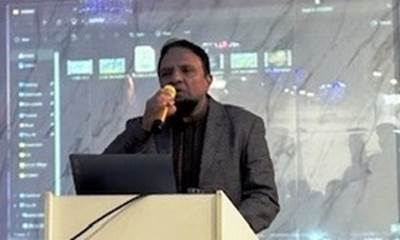 A person speaking into a microphone
Description automatically generated