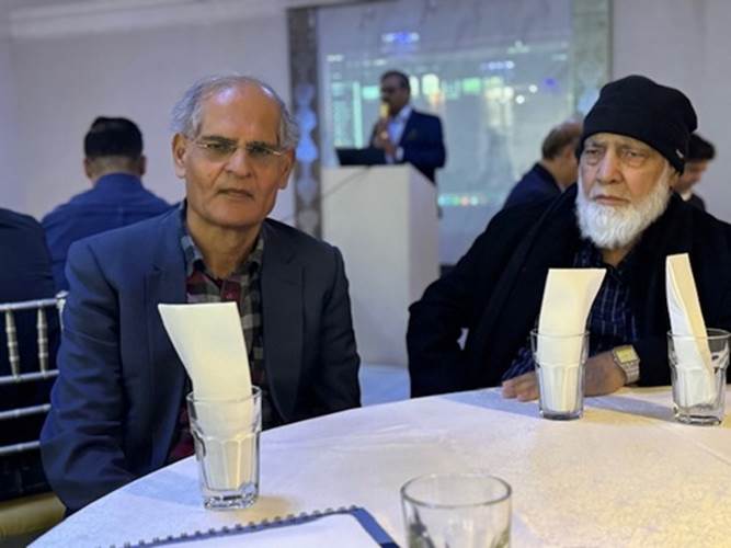 Two men sitting at a table
Description automatically generated