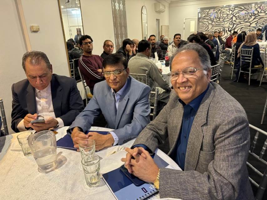 A group of men sitting at a table
Description automatically generated