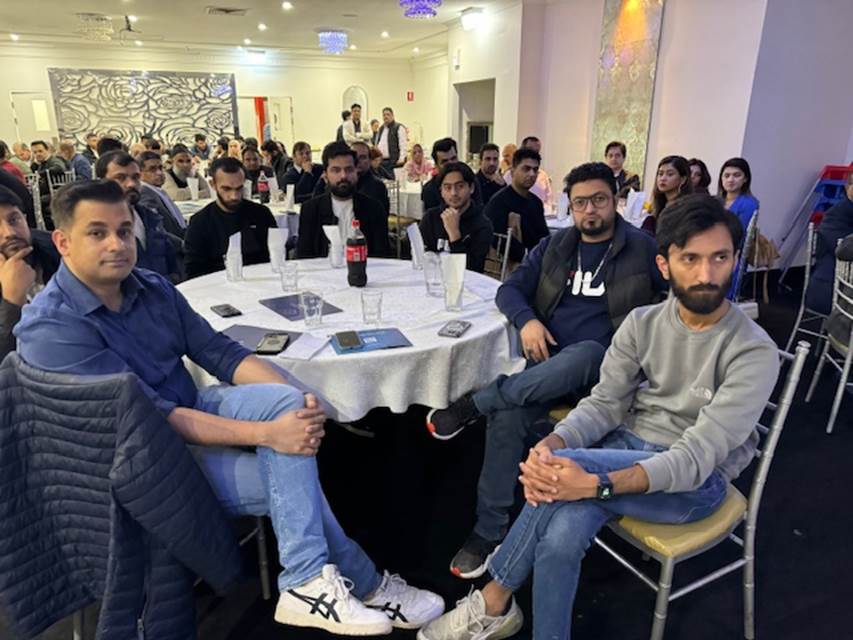 A group of people sitting around a table
Description automatically generated