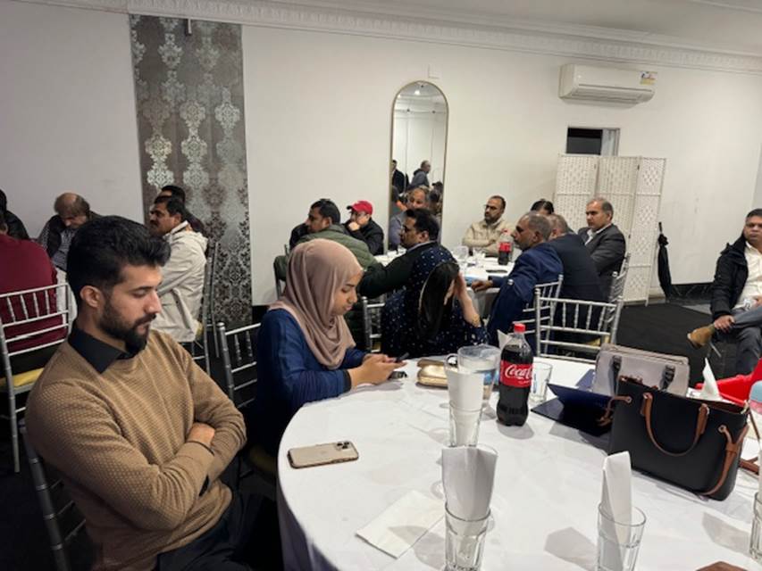 A group of people sitting around a table
Description automatically generated