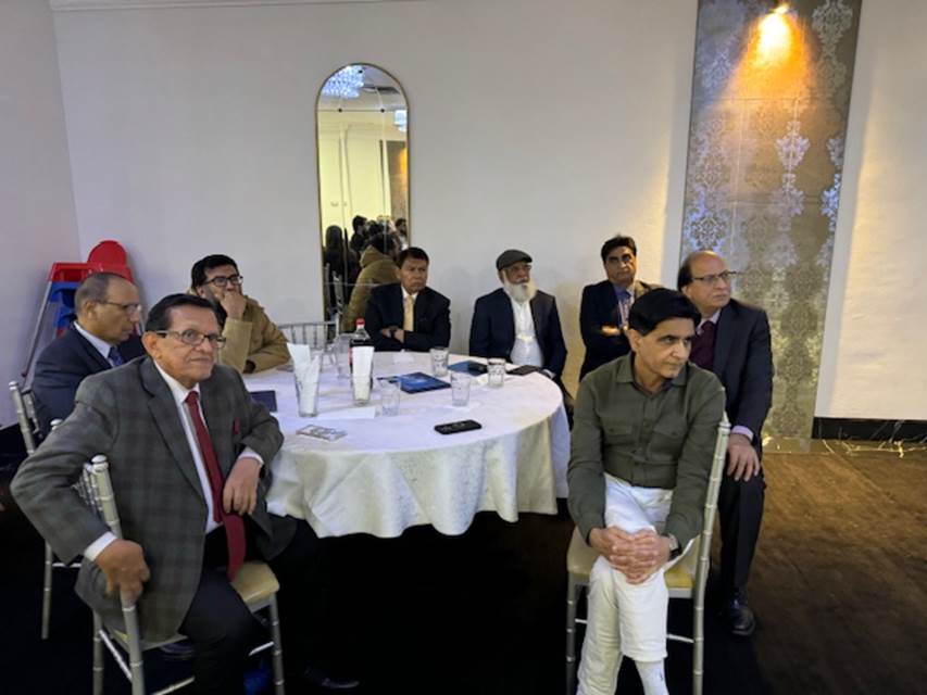 A group of men sitting at a round table
Description automatically generated