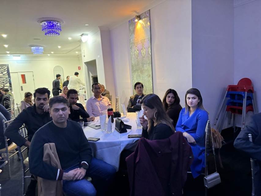 A group of people sitting around a table
Description automatically generated