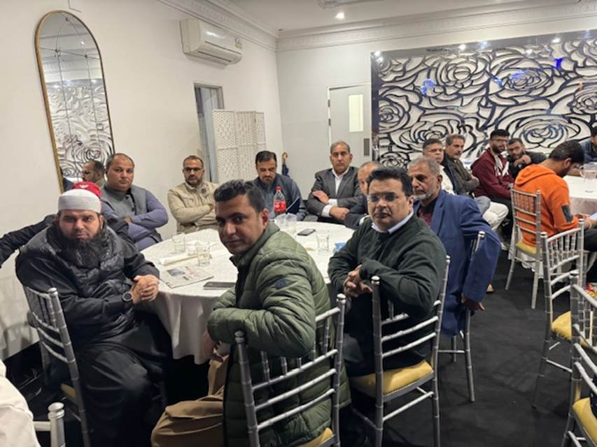 A group of men sitting at a table
Description automatically generated
