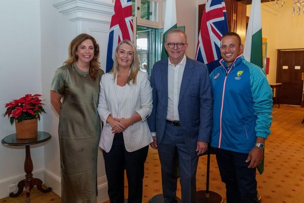 A group of people standing in front of flags

Description automatically generated