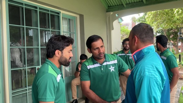 A group of men in green shirts

Description automatically generated