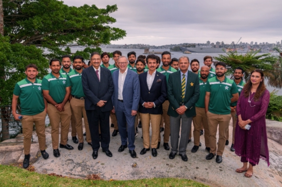 A group of men in green shirts

Description automatically generated
