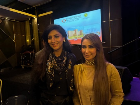 Two women standing next to each other
Description automatically generated