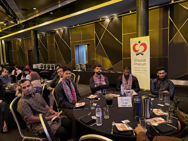 A group of people sitting around a round table
Description automatically generated