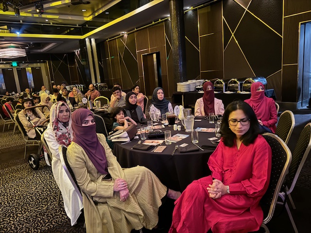 A group of people sitting at a table
Description automatically generated