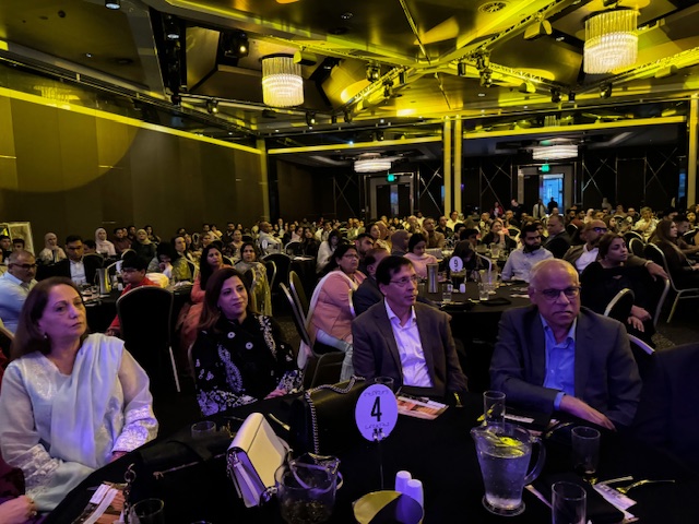 A group of people sitting at tables in a room
Description automatically generated