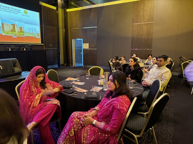 A group of people sitting around a round table
Description automatically generated