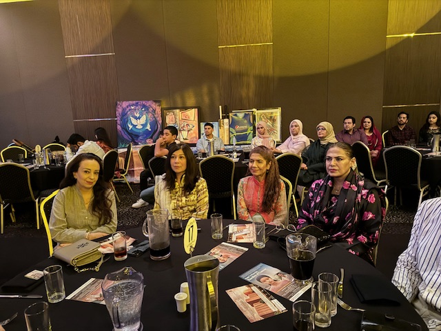 A group of people sitting at a round table
Description automatically generated