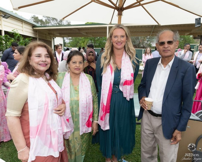 A group of people standing under a tent

Description automatically generated