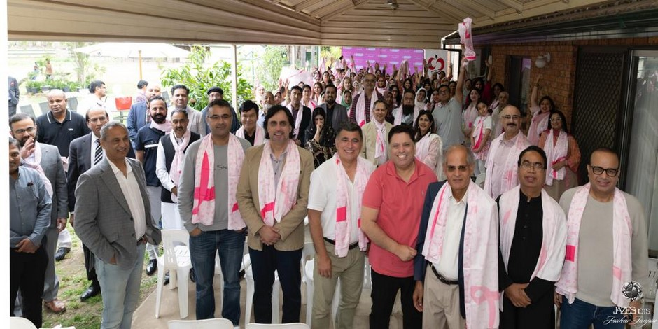 A group of people wearing pink scarves

Description automatically generated