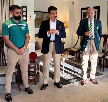 A group of men standing in a room

Description automatically generated