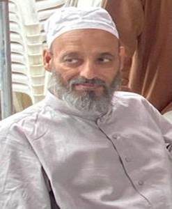 A person with a beard and white hat
Description automatically generated