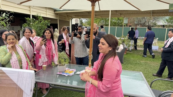 A group of people taking pictures of a person at a table

Description automatically generated