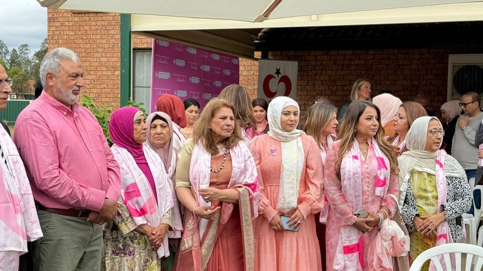 A group of women wearing pink scarves

Description automatically generated