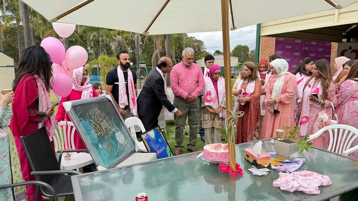 A group of people standing around a table

Description automatically generated